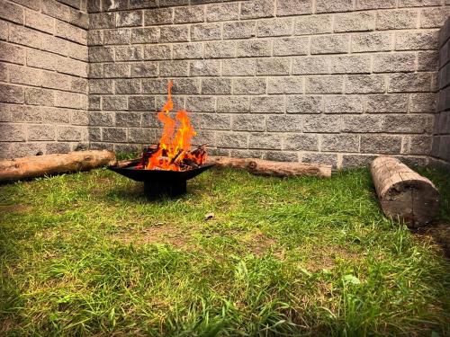a fire pit in the grass next to a brick wall at Bedroom La Casa Dilijan N1 in Dilijan