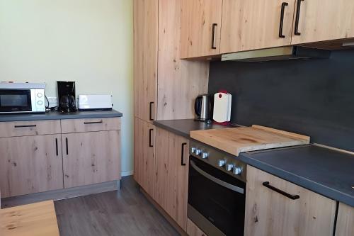 a kitchen with wooden cabinets and a stove top oven at Bei Heike 1 in Zetel