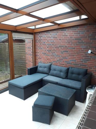a patio with a couch and a table at Bei Heike 1 in Zetel