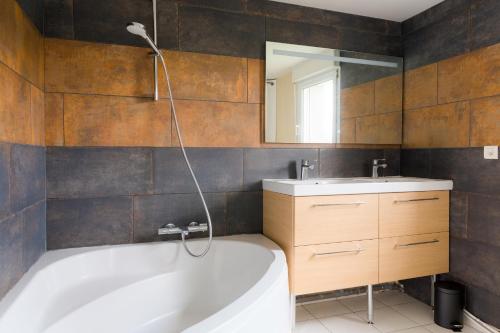 une salle de bain avec une baignoire et un lavabo dans l'établissement Maison pour 6 avec jardin - Centre de Névez, à Névez