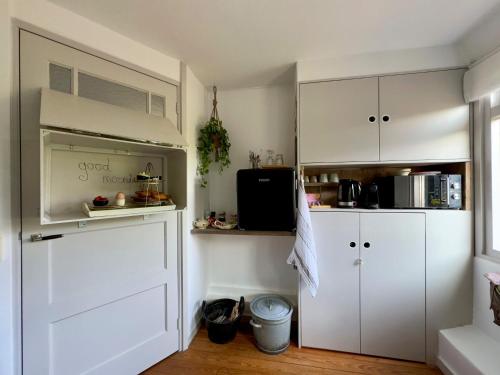 a kitchen with white cabinets and a door at B en B Sluisje 1818 in Utrecht