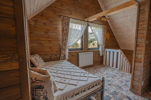 a bedroom with a bed in a wooden house at Moonlake Chalet in Găineşti