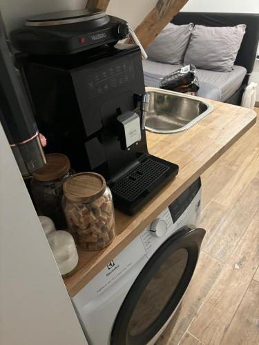 une cuisine avec un four micro-ondes et un ordinateur portable sur un comptoir dans l'établissement Petit studio a proximité des Galeries Lafayette, à Paris