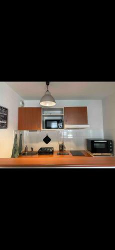 une cuisine avec un évier et un plan de travail dans l'établissement Appartement calme centre ville avec place parking, à Limoges