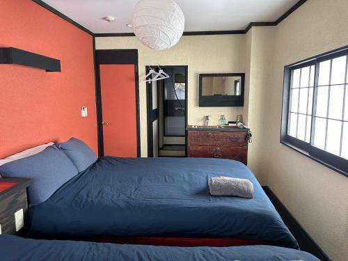 a bedroom with a blue bed and a sink at Hotel粋 in Hakodate