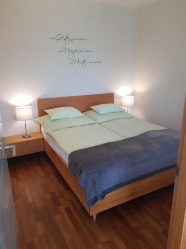 a bedroom with a large bed with two lamps at Zegg-Lounge in Seeboden