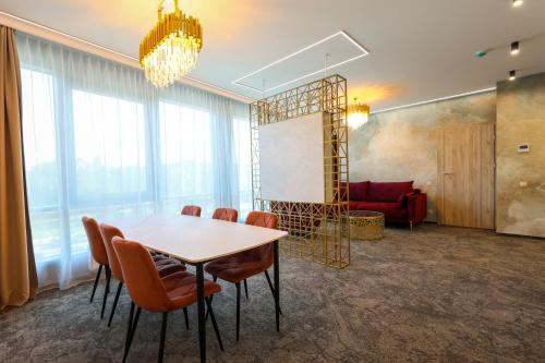 a room with a table and chairs and a couch at Suncity Hotel & SPA in Šiauliai