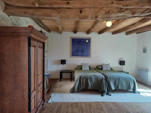 une chambre avec deux lits et un plafond en bois dans l'établissement La Verte Dordogne, à Villars