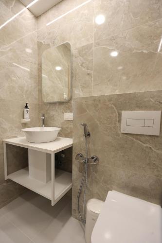 a bathroom with a sink and a toilet and a mirror at Suncity Hotel & SPA in Šiauliai