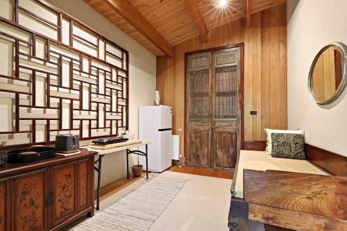 a room with a refrigerator and a table with a bench at Birch Suite - Rocky Creek Art Garden in Olinda