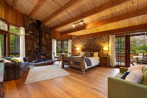 a living room with a bed and a fireplace at Beech Suite - Rocky Creek Art Garden in Olinda