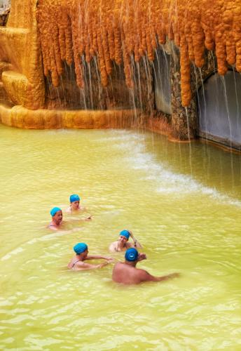 a group of people swimming in a body of water at Pam Thermal Hotel Clinic & Spa in Pamukkale