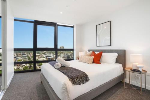 a bedroom with a large bed and large windows at Deluxe Living in Southbank, Parking Available T&Cs in Melbourne