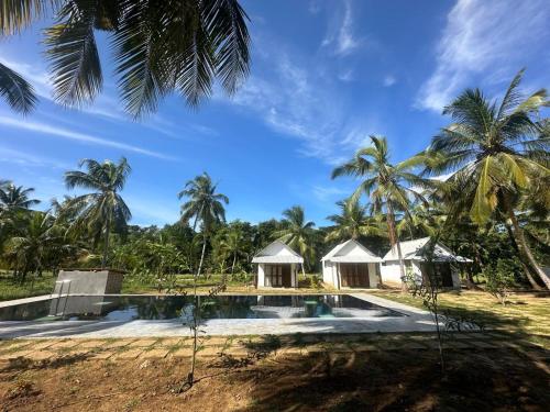 an image of a resort with a swimming pool and palm trees at A Frame Cottage Udawalawe in Timbulketiya