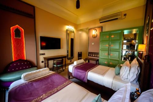 a hotel room with two beds and a table at BrijRama Palace, Varanasi - By the Ganges in Varanasi