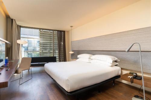 a hotel room with a large bed and a desk and a desk at B Hotel in Barcelona