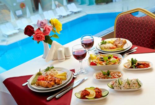 a table with plates of food and glasses of wine at Pam Thermal Hotel Clinic & Spa in Pamukkale