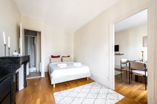 une chambre blanche avec un lit et une table dans l'établissement Jardin du Luxembourg I Fully equipped with View, à Paris