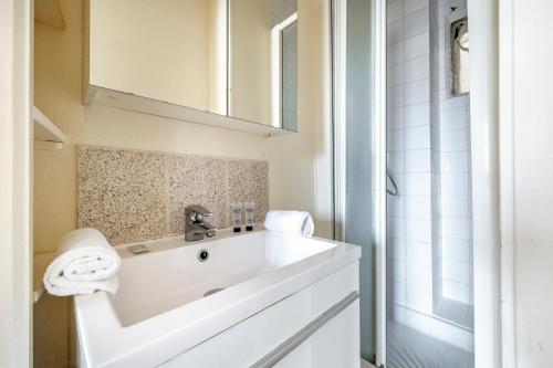 une salle de bain blanche avec un lavabo et une douche dans l'établissement Jardin du Luxembourg I Fully equipped with View, à Paris