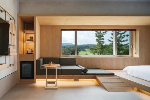 a bedroom with a couch and a bed and a window at Kinock in Gyeongju