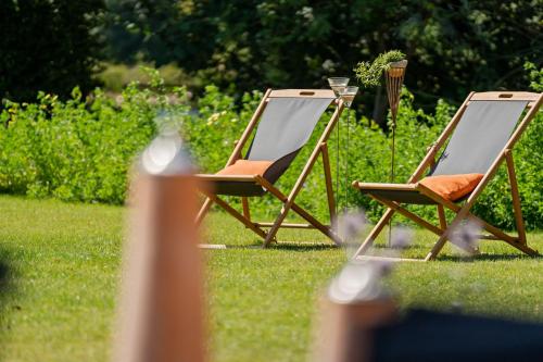 two chairs sitting in the grass in a yard at Dat Schniederhus in Ehrenburg