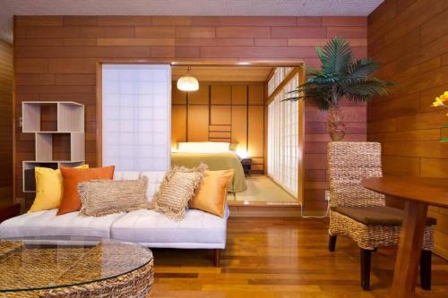 a living room with a couch and a bedroom at 安里戸建て in Tomari
