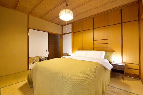 a bedroom with a large bed with a wooden wall at 安里戸建て in Tomari