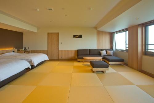 a bedroom with a bed and a couch and a table at 山荘 風の杜 Sanso Kazenomori in Minoo