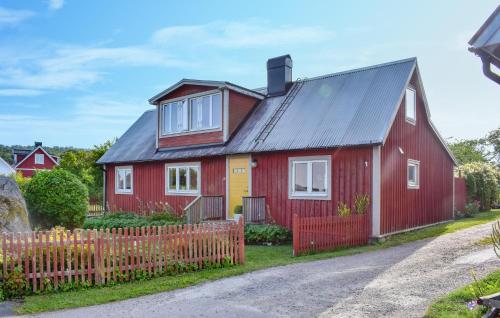 a red and yellow house with a wooden fence at 4 Bedroom Gorgeous Home In Sölvesborg in Sölvesborg