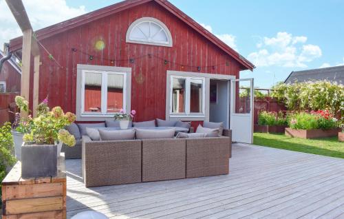 a red barn with couches on a wooden deck at 4 Bedroom Gorgeous Home In Sölvesborg in Sölvesborg