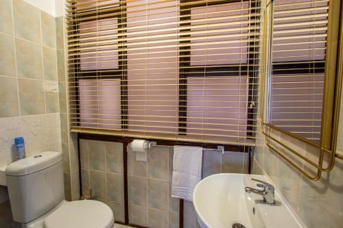 a bathroom with a toilet and a sink at Uvongo Cabanas 15A in Uvongo Beach
