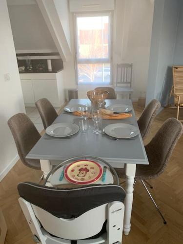 une table à manger avec des chaises et une table grise avec une plaque de cuisson dans l'établissement Chessy-bourg , 5 minutes Disneyland, à Chessy
