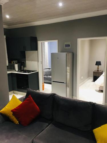 a living room with a couch and a kitchen at Kwakwethu in Bulawayo