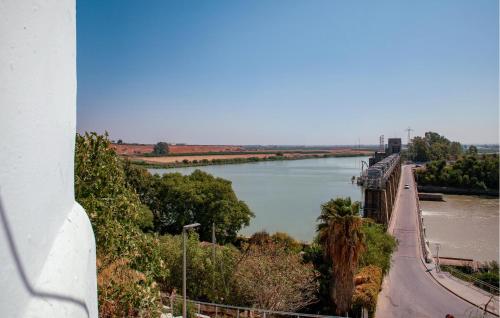 a bridge over a river with a train on it at 2 Bedroom Nice Home In Alcalá Del Río in Alcalá del Río