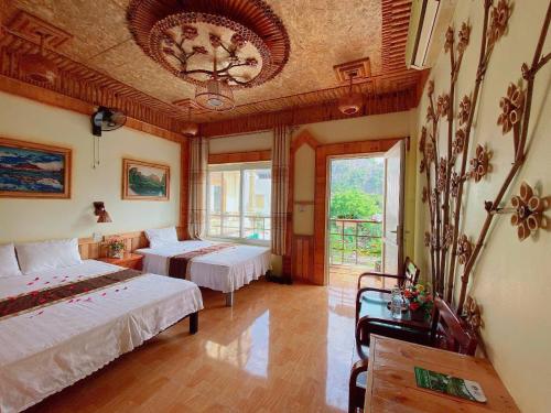 a bedroom with two beds and a large window at Trang An Central Homestay in Ninh Binh