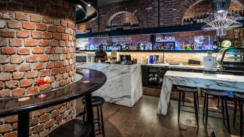 a bar with a brick wall and a person standing at a counter at City Hidden Gem in Melbourne