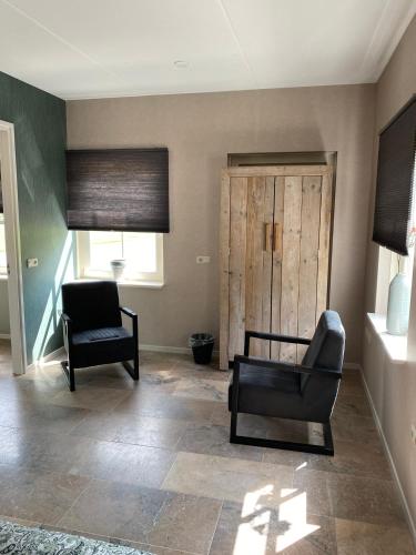 a living room with a chair and a door at Appartement Zeldam in Ambt Delden