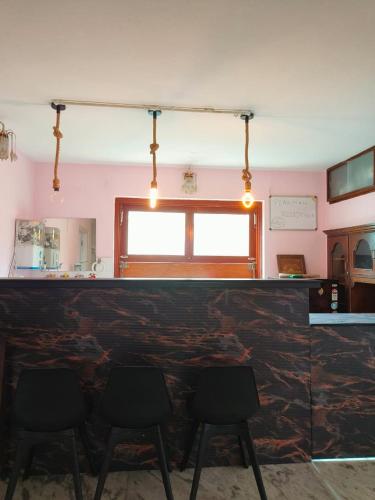 a bar with four black chairs in a room at Peakman Residence in Kathmandu