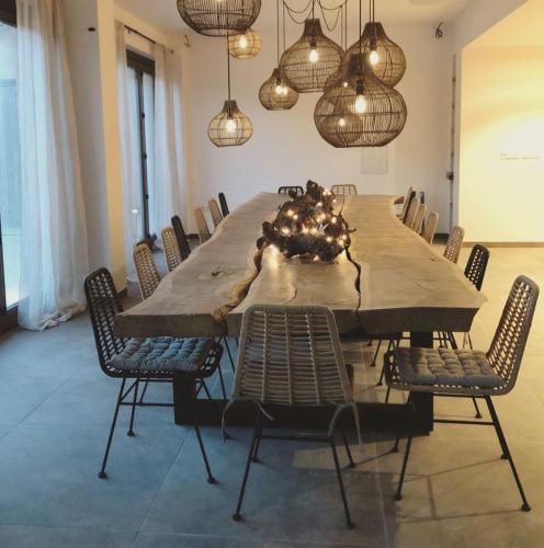 a large dining room table with chairs and lights at Torres De Selma - Eco Resort in El Pla de Manlleu