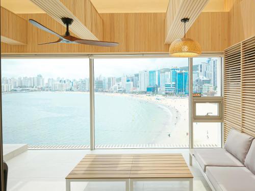 a living room with a view of a beach at B'amu Hotel in Busan
