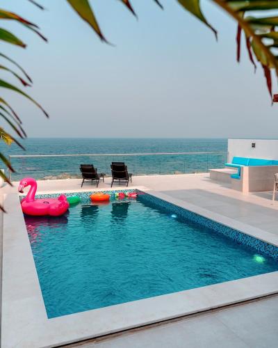 a swimming pool with an inflatable flamingo in the water at Seascape Villa in Fujairah