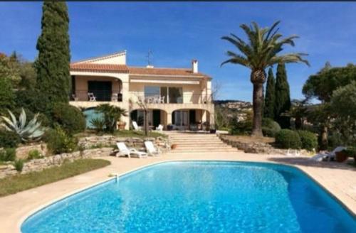 une maison avec une piscine devant une maison dans l'établissement Villa Serenite, aux Issambres