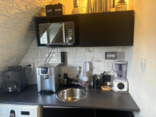 un comptoir de cuisine avec un évier et un micro-ondes dans l'établissement Studio avec vue sur Sacré-Coeur, à Paris