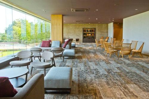 a waiting room with tables and chairs and windows at 山荘 風の杜 Sanso Kazenomori in Minoo