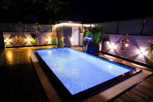 a large swimming pool with lights in a house at BluStone By The StayCationer in Malavli