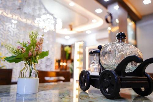 a table with a vase with a glass dome and a vasemoilmoil at BluStone By The StayCationer in Malavli