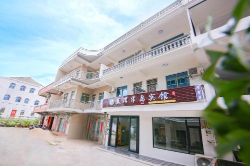 a building with a sign on the side of it at 莆田市湄洲岛蓝湾半岛宾馆妈祖祖庙店 in Putian