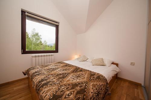 Un dormitorio con una cama grande con ventana. en Apartment Gledovic, en Zlatibor