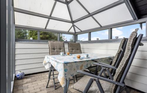 a screened in porch with a table and chairs at 2 Bedroom Amazing Home In Thisted in Thisted
