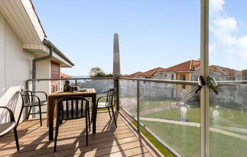 a balcony with a table and chairs and a window at Gudhjem Søpark Lejl 42 in Gudhjem